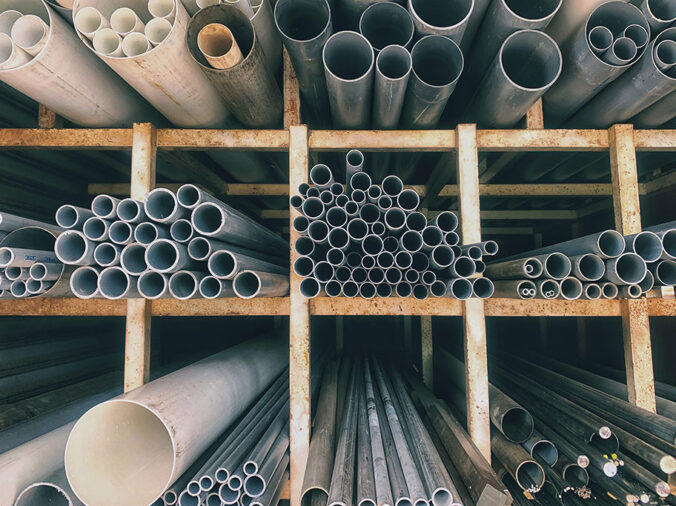 PVC and steel plumbing pipe on shelves in a plumbing supply warehouse