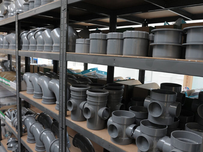 Grey PVC elbows and connectors in a plumbing supply warehouse