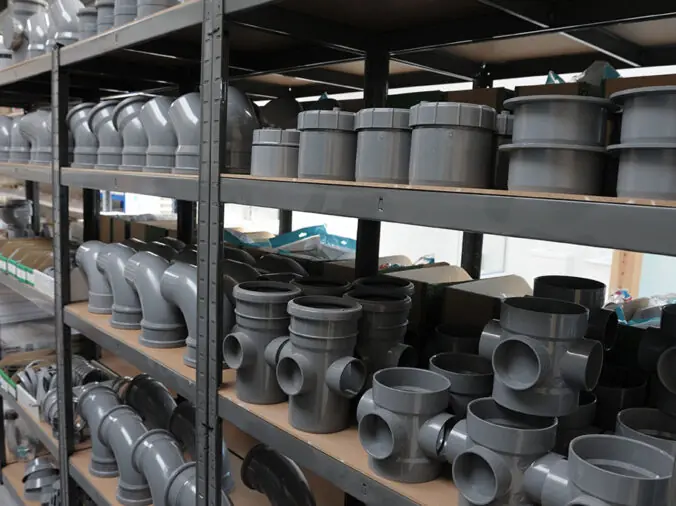 Grey PVC elbows and connectors in a plumbing supply warehouse